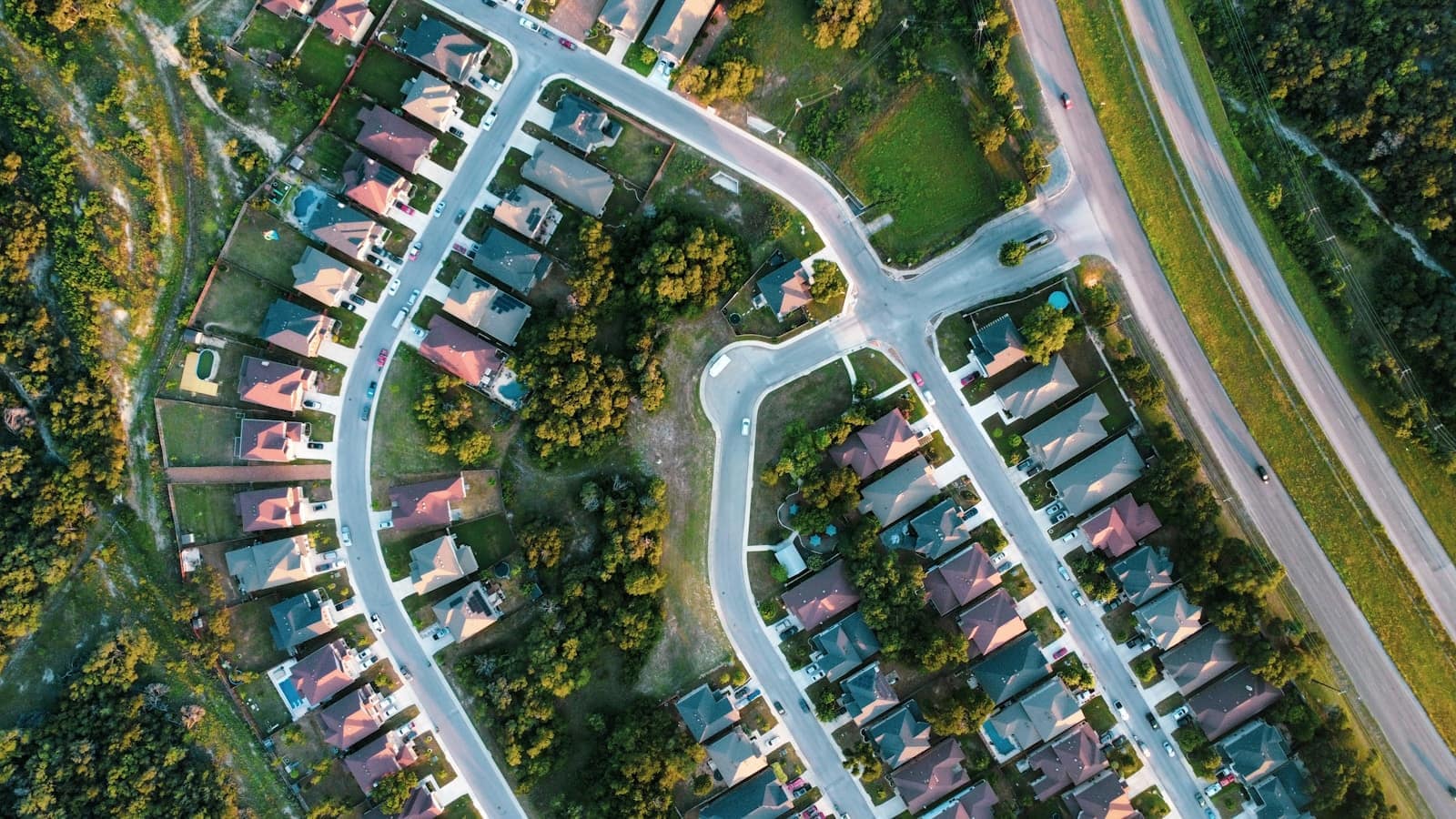 Aerial view of a suburban neighborhood with winding streets and trees